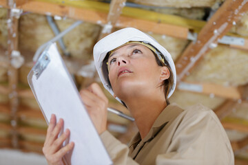 female inspector looking at ceiling in property to renovate