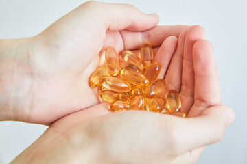 Yellow capsules of vitamin omega 3 in your hand. Biologically active additive. Fish oil in tablets....