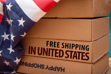 Fototapeta na wymiar Free Shipping across United States of America wrriten on carton boxes with flag.
