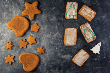Fototapeta na wymiar Various christmas gingerbread cookies on dark table with flour