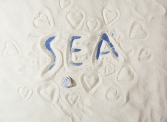 Background of fine sand with the inscription sea and hearts. Summer, beach, sea.