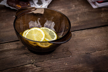  A plate with slices of lemon on a wooden table