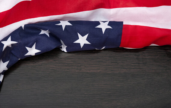 USA flag fabric floating on wooden background banner with copy space.