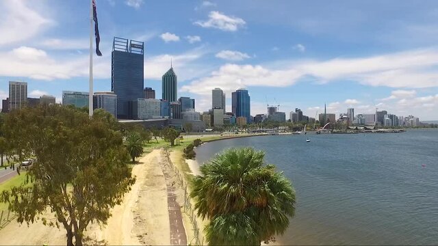 Beautiful drone shot flying towards Perth CBD in Western Australia on a gorgeous summers day, blue skies with few clouds. Including the Australian flag flying in the wind.