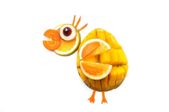 Food art creative concepts. Funny bird made of fruits and vegetables, such as orange, mango and carrots isolated on a white background