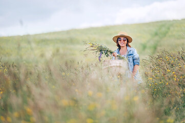Sincerely smiling young Woman dressed jeans jacket and light summer dress walking by the high green...