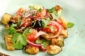 eggplant salad with sesame seeds and tomatoes closeup