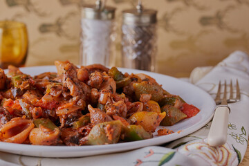 Chicken with vegetables and pasta,plus some condiments in the background.