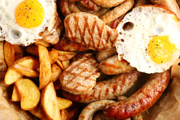 bavarian sausage plate with potatoes and fried egg. Grilled sausages closeup. Top view with copy space Appetizing beer snacks set.