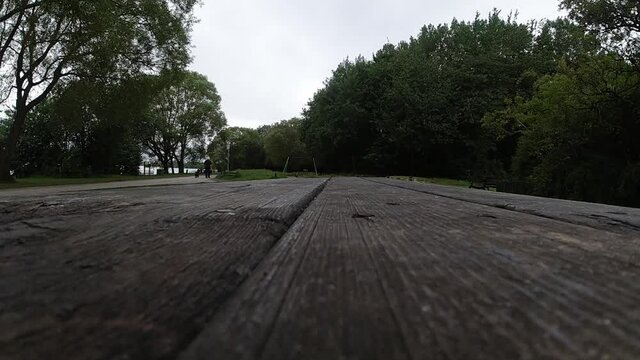 Multiple metallic nitrous oxide gas cylinder recreational drug slow motion falling onto wooden park bench