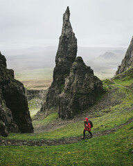 Traveler with a backpack hiking the Quiraing Isle of Skye Scotland. Beautiful nature of Great Britain. Tourism active life and adventures in the mountains.