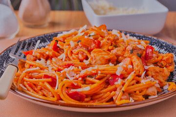 Chicken with pasta and vegetables,sprinkled with  cheese.