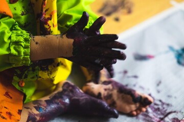 Little kid hands and feet covered with multiple colours