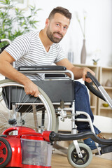 disabled man in wheelchair vacuum cleaning house