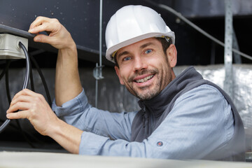 handsome joyful electrician in hardhat