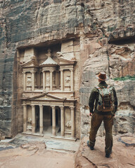 A traveler in a hat with a backpack looks at Al-Khazneh in Petra. Indiana Jones near the treasury...