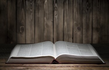 Open book on old wooden table.