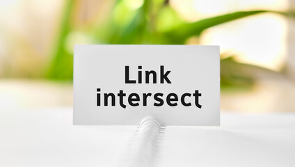 Link intersect business seo concept text on a white notebook and green flowers