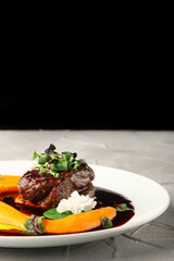 filet mignon with mashed pumpkin and microgreen in white plate on concrete background