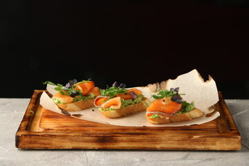 Selection of tasty bruschetta or canapes with salmon closeup. salmon tapas with guacamole and topped microgreen