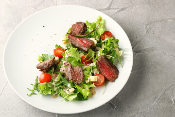 steak salad with leaf of salad fresh cherry tomatoes parmesan cheese and summer sauce closeup