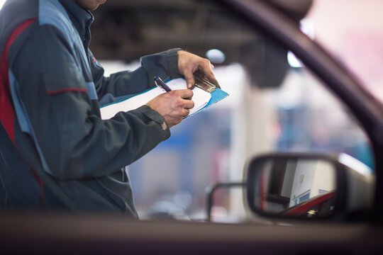 Inside A Garage - Mechanic Carrying Out Repairs (shallow DOF; Color Toned Image)