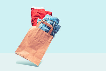 Flying shopping paper bag with purchases. Concept of consumerism, ease of shopping. Copy space trend pastel colors.