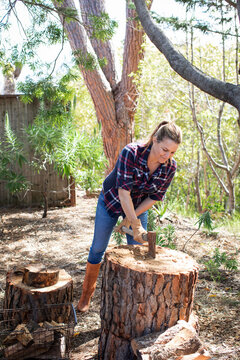 Woman chopping wood outdoors
