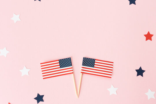 Two usa flag toothpick and star around on pink background, flat lay. 4th of july in America, celebration independence day in usa. Copy space for text in center.