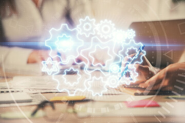 Double exposure of woman hands typing on computer and business theme hologram drawing. Success...