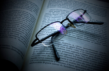 A open book in spanish with glasses.