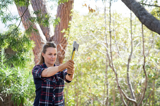 A woman doing the sport of ax throwing