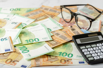 Calculator and glasses on euro money background