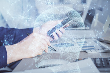 Double exposure of man's hand holding and using a digital device and brain hologram drawing. Data concept.