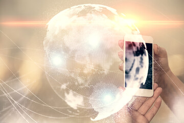 Double exposure of business theme sketch hologram and woman holding and using a mobile device.