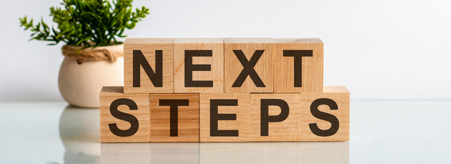 Next Steps motivation text on wooden blocks business concept white background.