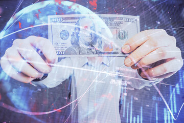 Multi exposure of financial graph drawing hologram and USA dollars bills and man hands. Analysis concept.