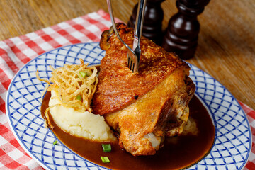 Baked pork knuckle with sauerkraut and mustard on wooden background. Top view