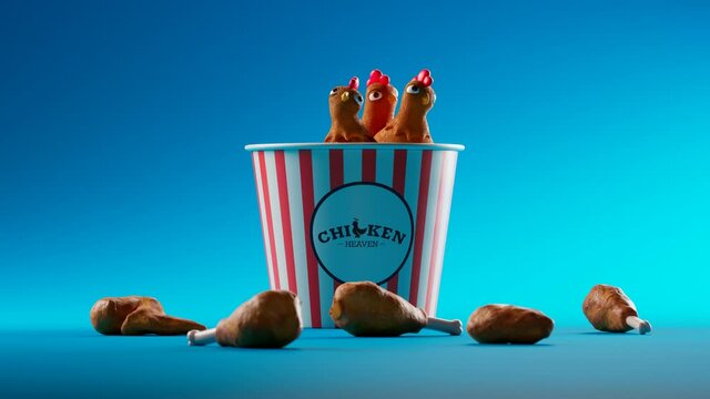 Animation of curious chickens peeking out of a paper bucket of fried chicken.