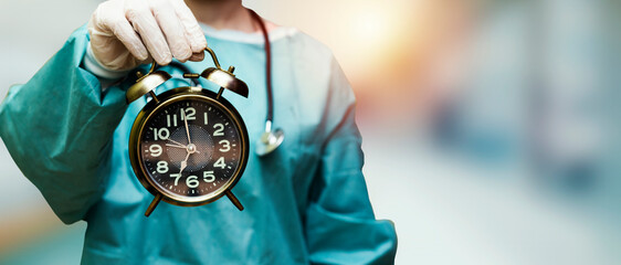 surgeon doctor woman holding alarm clock showing 7 am or pm