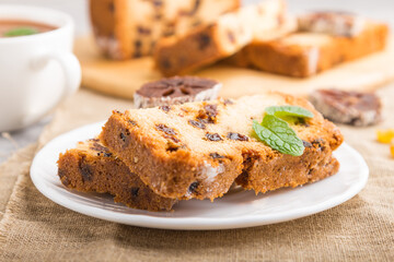 Homemade cake with raisins, dried persimmon and a cup of hot chocolate on a gray concrete background. side view, selective focus.