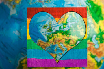 LGBT and pride day.Rainbow colored heart with symbols of lesbians, gays, transgender people and bisexuals on a globe background.