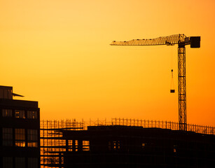 Large crane and construction site under construction at sunset, suburbs Milan