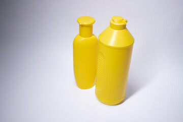 Composition of two yellow shampoo bottles with no label. body care and beauty concept. Copy space. Isolated. High quality photo