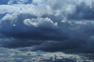 Close up of blue sky with a light and dark clouds.