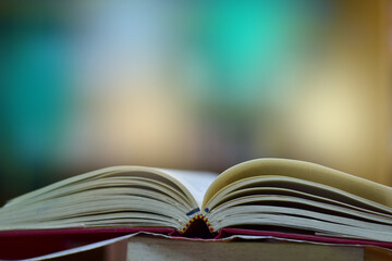 Open Book on wood table and blurred bookshelf in the library, education background, back to school concept.
