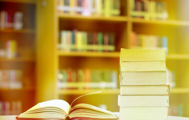 Open Book on wood table and blurred bookshelf in the library, education background, back to school concept.