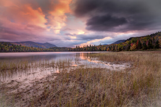 Scenic landscape with orange and black skies in Autumn at Connery Pond, Adirondacks, New York State.