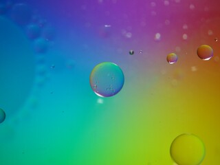 Closeup oil bubbles with colorful background and blurred droplets ,macro image ,sweet pastel color ,rainbow and colorful balloons background, abstract background