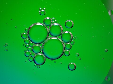 Closeup green oil bubbles with colorful background and blurred droplets ,macro image ,sweet pastel color ,rainbow and colorful balloons background, abstract background